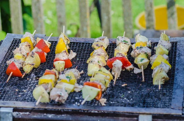 Espetos saborosos de peixe fresco com legumes e maçãs em um prato de carne shish de madeira — Fotografia de Stock