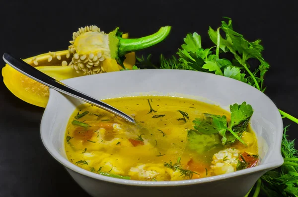 Вкусный суп с овощами и рыбой на черном фоне — стоковое фото