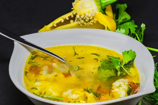Вкусный суп с овощами и рыбой на черном фоне — стоковое фото