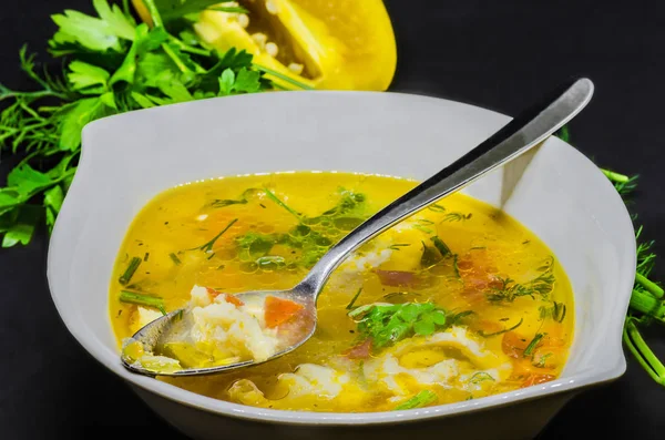 Una deliciosa sopa con verduras y pescado sobre un fondo negro —  Fotos de Stock