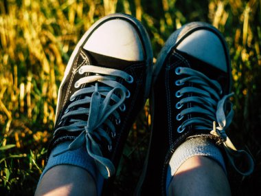 Parktaki çimlerin üzerinde spor ayakkabı giymiş güzel bir kadın.