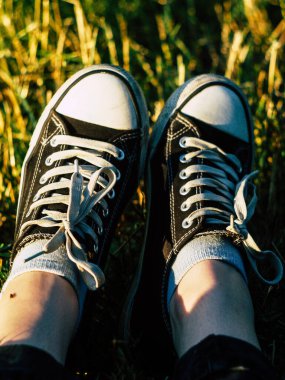 Parktaki çimlerin üzerinde spor ayakkabı giymiş güzel bir kadın.