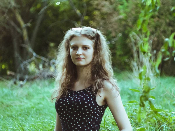 Krásná blondýna dívka v šatech na pozadí letního zeleného pole — Stock fotografie