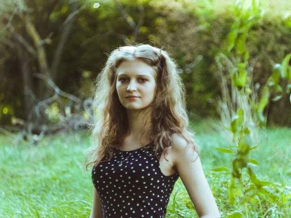 Krásná blondýna dívka v šatech na pozadí letního zeleného pole — Stock fotografie