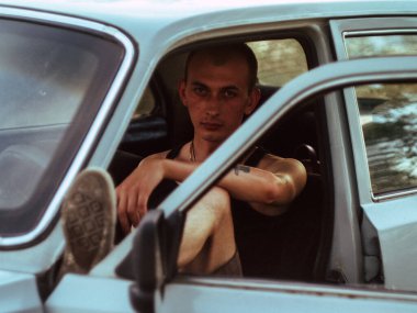 Yaşlı, yakışıklı, dövmeli adam.