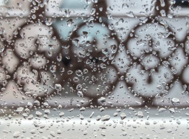 Soyut arkaplan, su damlalarıyla ıslanan bir pencerenin camı diğer nesneler ve odak dışı dekorasyon.