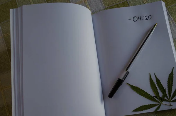 Anteckningsbok med texten "420", några gröna marijuanablad och en svart penna. Begreppet att söka inspiration. — Stockfoto