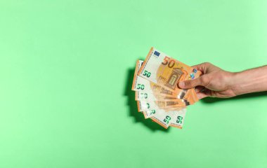 Sağ taraftan 50 Euro 'luk banknotlar, yeşil arka planda izole edilmiş. Para kazanma, kumar, zafer, bahis...