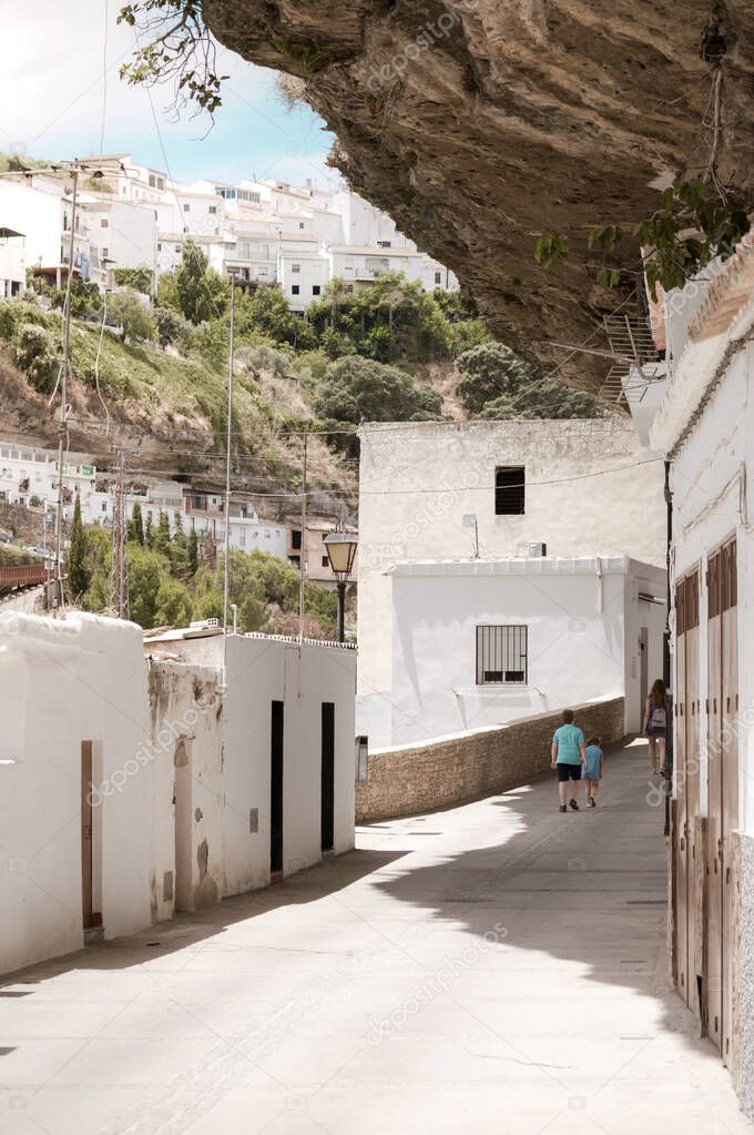 White houses built into rock in Setenil de las Bodegas, Cadiz, famous white town (Pueblos Blancos) of Andalusia, Spain. Touristic village on sunny day.