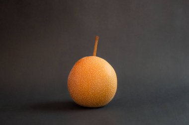 Taze Nashi ya da koyu armutlar. Pyrus Pyrifolia 'ya yakın, koyu arkaplanda nadir bulunan bir meyve türü..