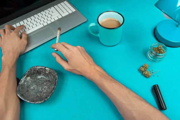 Person Smoking Marijuana Joint While Working Blue Table Computer Coffee Royalty Free Stock Photos