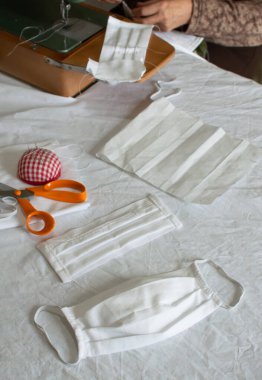 Evde koruyucu maske yapıyorum. Tıbbi maske ve malzemeler arka planda dikiş dikmek için..