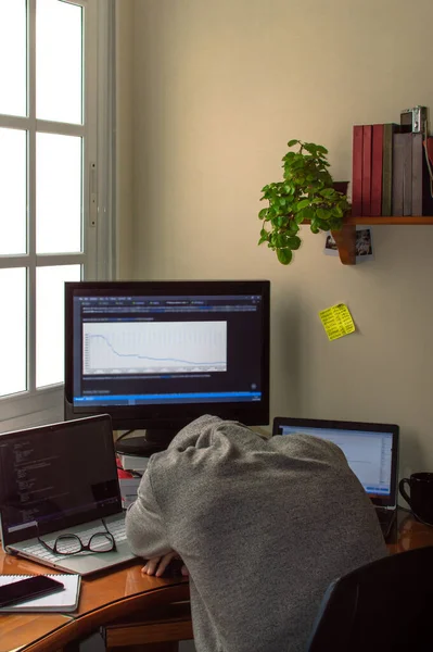 Sleeping man on the desk while working from home. Space to remote work at home. Concept of telecommuting or teleworking.