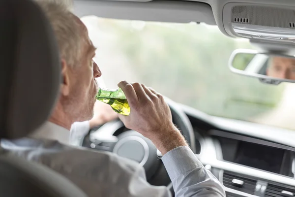 Mann trinkt Alkohol und fährt Auto — Stockfoto