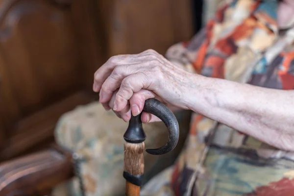 Vieja con las manos en un bastón — Foto de Stock