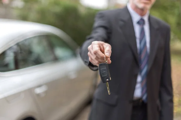 Muž nabízí klíč od auta — Stock fotografie