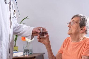 Bir hasta için bir bardak su veren doktor