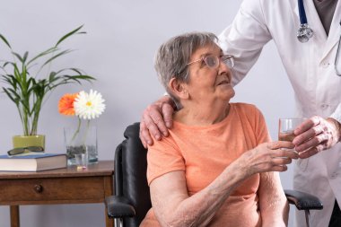 Bir hasta için bir bardak su veren doktor