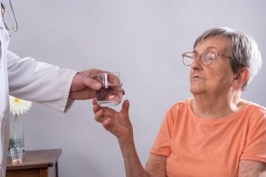 Bir hasta için bir bardak su veren doktor