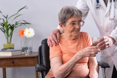 Bir hasta için bir bardak su veren doktor