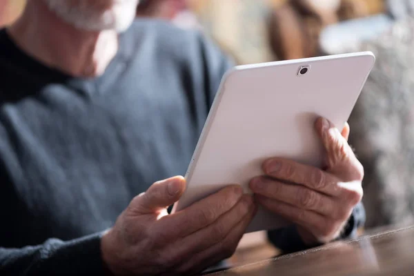 Senior man met zijn tablet, harde lichteffect — Stockfoto