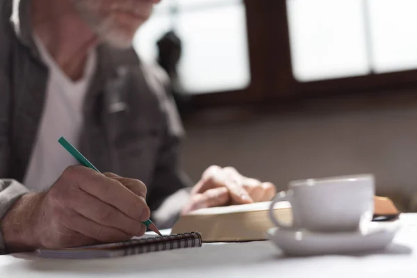 Man lezen van een boek en het maken van notities, harde lichteffect — Stockfoto