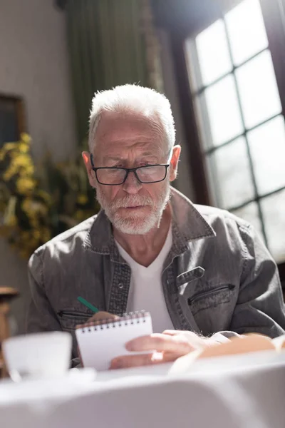 Man taking notes, hard light effect — Stock Photo, Image