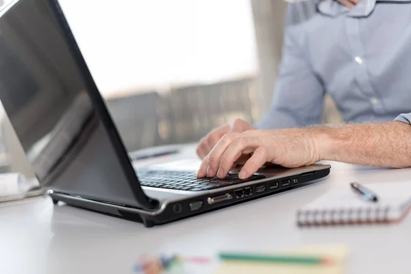 Homme d'affaires travaillant sur ordinateur portable, lumière dure — Photo