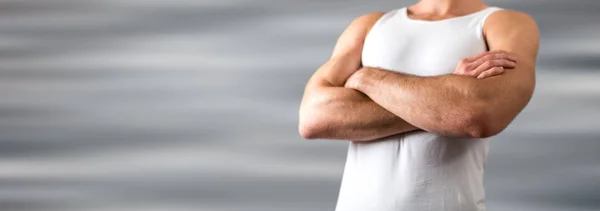 Homme athlétique aux bras croisés portant une chemise blanche — Photo