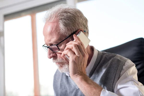 Skäggiga senior affärsman talar på mobiltelefon, hårt ljus — Stockfoto