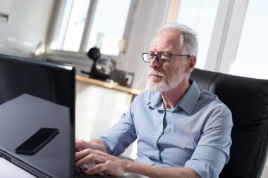 Dizüstü bilgisayar, sert ışık çalışan üst düzey işadamı portresi