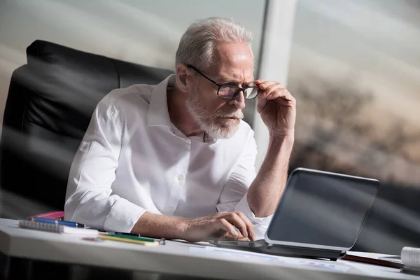 Senior affärsman arbetar på laptop, ljuseffekt, hårt ljus — Stockfoto