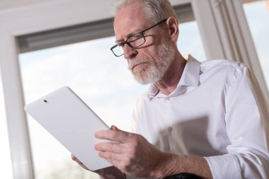 Üst düzey işadamı kullanarak bir dijital tablet, sert ışık