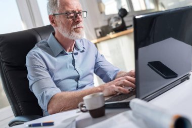 Dizüstü bilgisayar, sert ışık çalışan üst düzey işadamı portresi