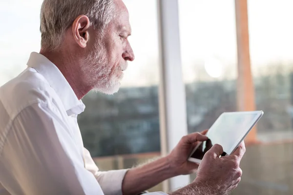 Üst düzey işadamı kullanarak bir dijital tablet, sert ışık — Stok fotoğraf