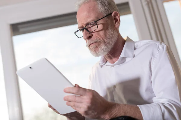 Senior affärsman med en digital tablett, hårt ljus — Stockfoto