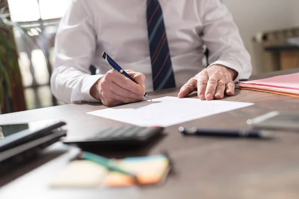 Geschäftsmann unterschreibt ein Dokument — Stockfoto