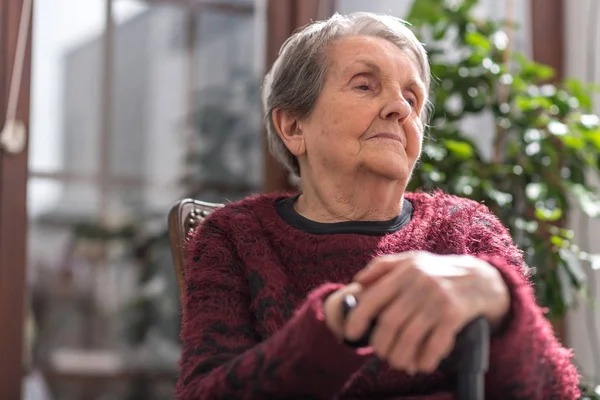 Vieja con las manos en un bastón — Foto de Stock