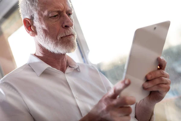 Senior zakenman met behulp van een digitaal tablet, lichteffect, harde li — Stockfoto