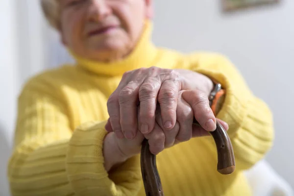 Vieja con las manos en un bastón — Foto de Stock