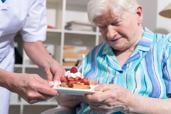 Starší žena obdrží narozeninový dortík od její sestry — Stock fotografie