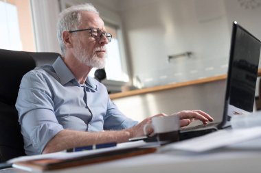 Dizüstü bilgisayar, sert ışık çalışan üst düzey işadamı portresi