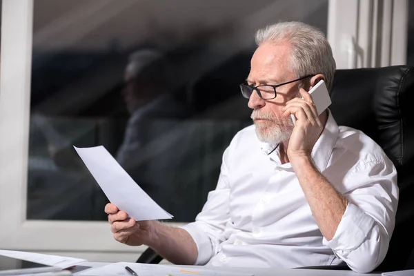 Γενειοφόρος ανώτερος επιχειρηματίας, μιλώντας σε κινητό τηλέφωνο, σκληρό φως — Φωτογραφία Αρχείου