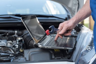 Makinist araba motoru kontrol etmek için dizüstü bilgisayar kullanarak
