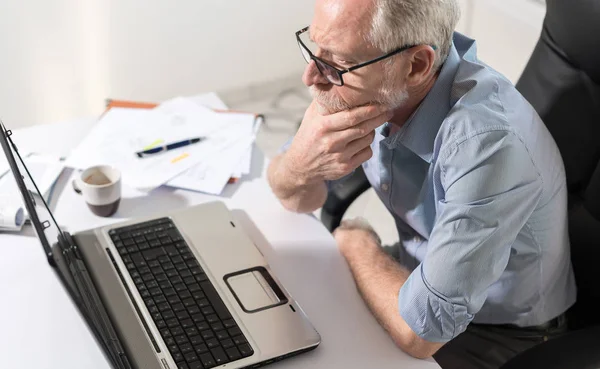 Nachdenklicher Geschäftsmann mit der Hand am Kinn — Stockfoto