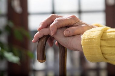 Yaşlı kadın bir baston tutan eller