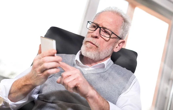 Senior zakenman met behulp van zijn mobiele telefoon, lichteffect — Stockfoto