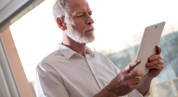 Senior zakenman met behulp van een digitaal tablet, hard licht — Stockfoto