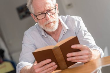 Kitap okuyan olgun bir adam.