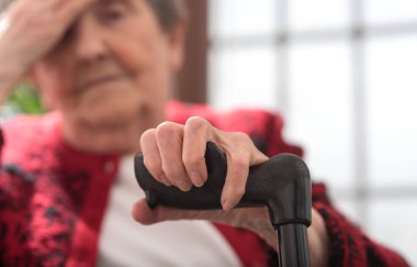 Baş ağrısı olan yaşlı bir kadın.